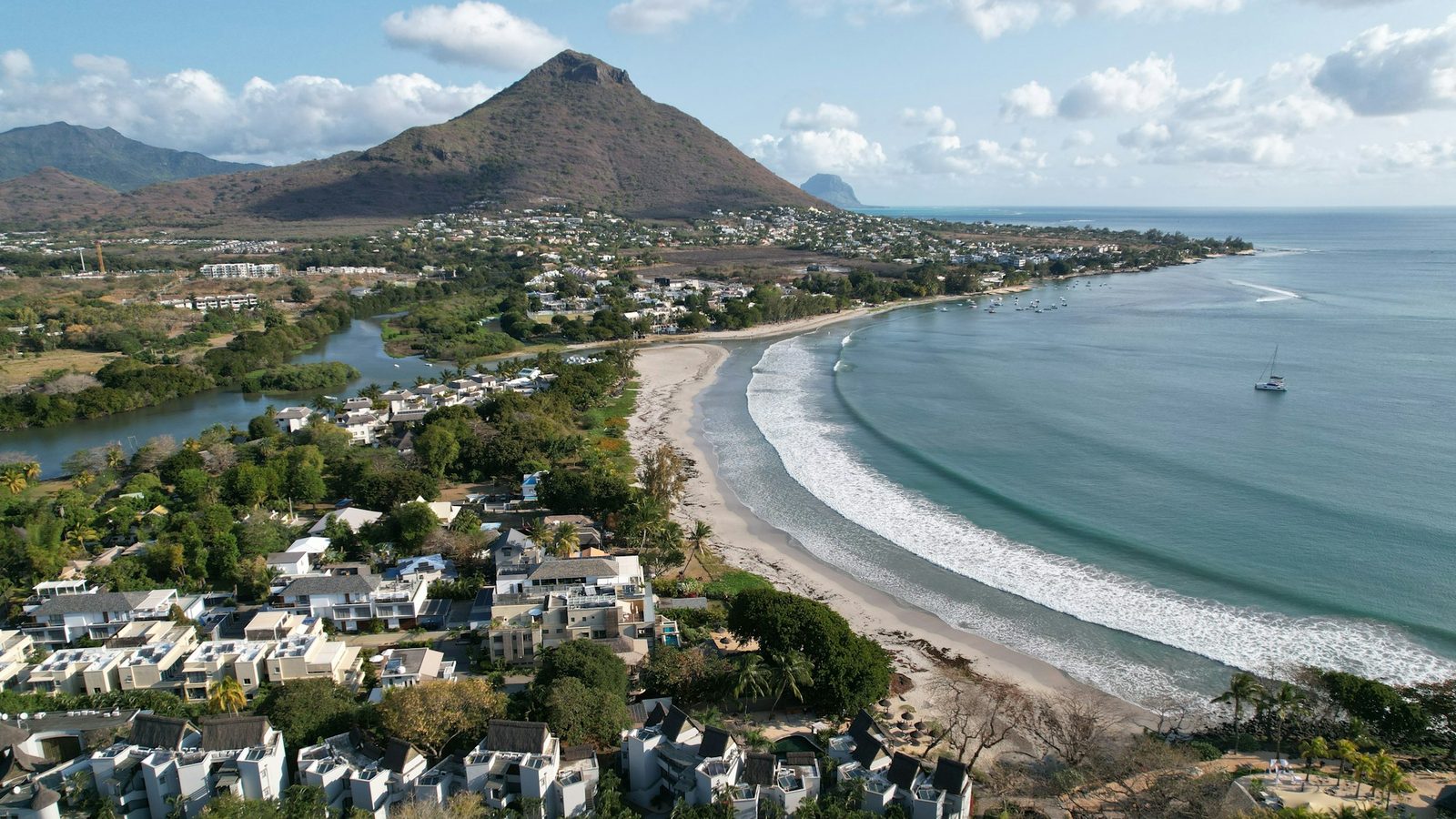 Aerial view of Tamarin on the west coast of Mauritius: houses along the bay with a mountain behind